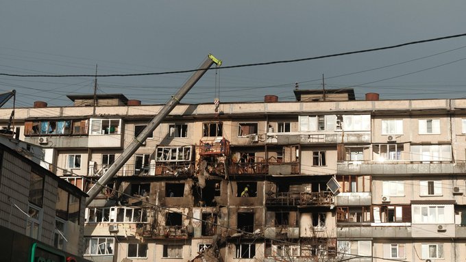 Пошкоджений багатоповерховий житловий будинок після обстрілу, зруйновані квартири та вибиті вікна.