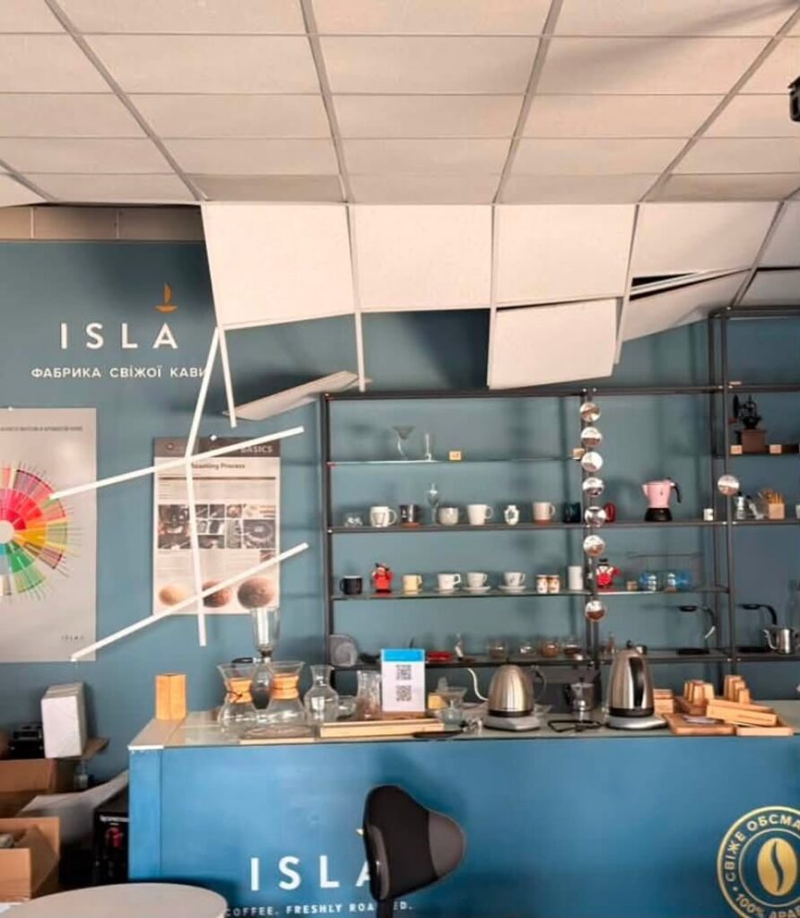 Інтер'єр кав'ярні "ISLA Фабрика свіжої кави" з пошкодженою підвісною стелею та стійкою.